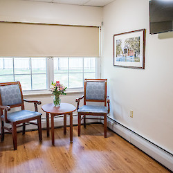 Small sunlit lounge area with TV at 60 West in Rocky Hill, CT